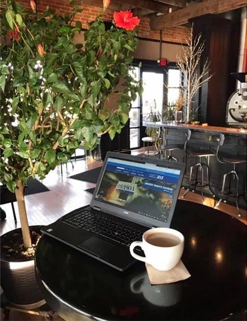 一张笔记本电脑和一杯咖啡在当地咖啡店的照片