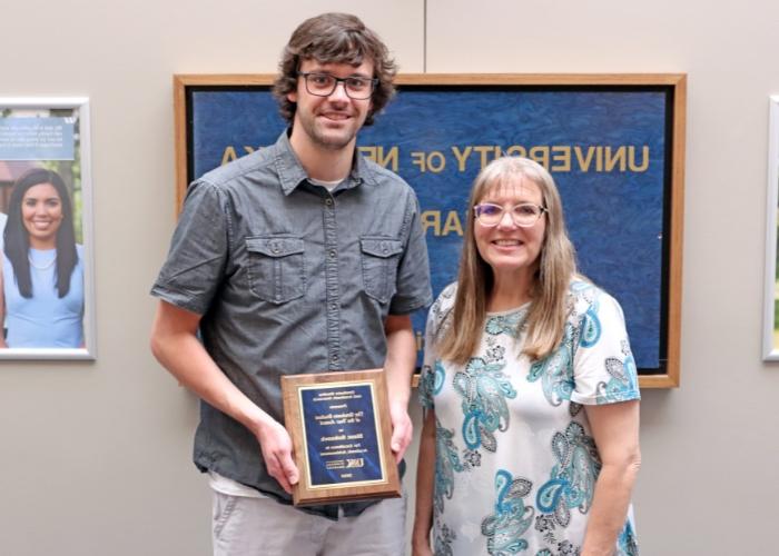 Student and professor pose with award.